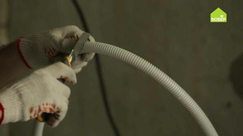 Монтируем электрический кабель: заводим в гофротрубу и крепим к стене